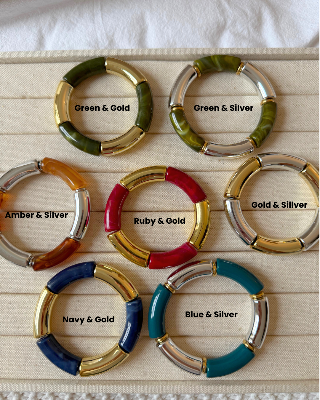 Set of colorful keychains with labeled color combinations on a wooden surface.
