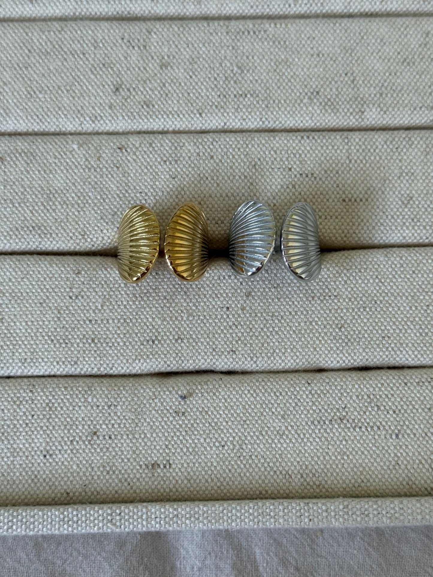 Four metallic knobs on a textured beige surface