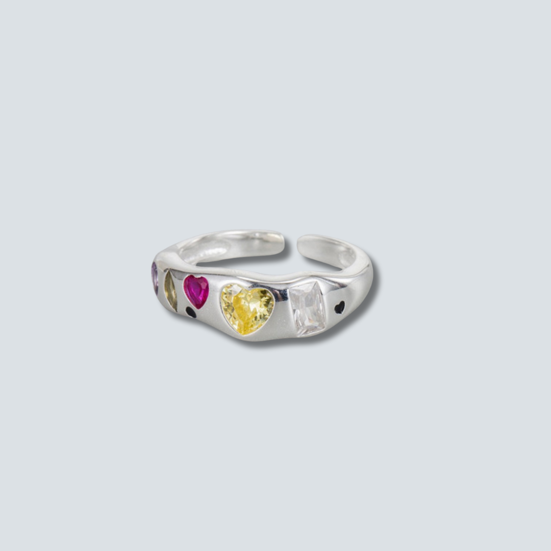 Silver ring with heart-shaped gemstones on a light gray background