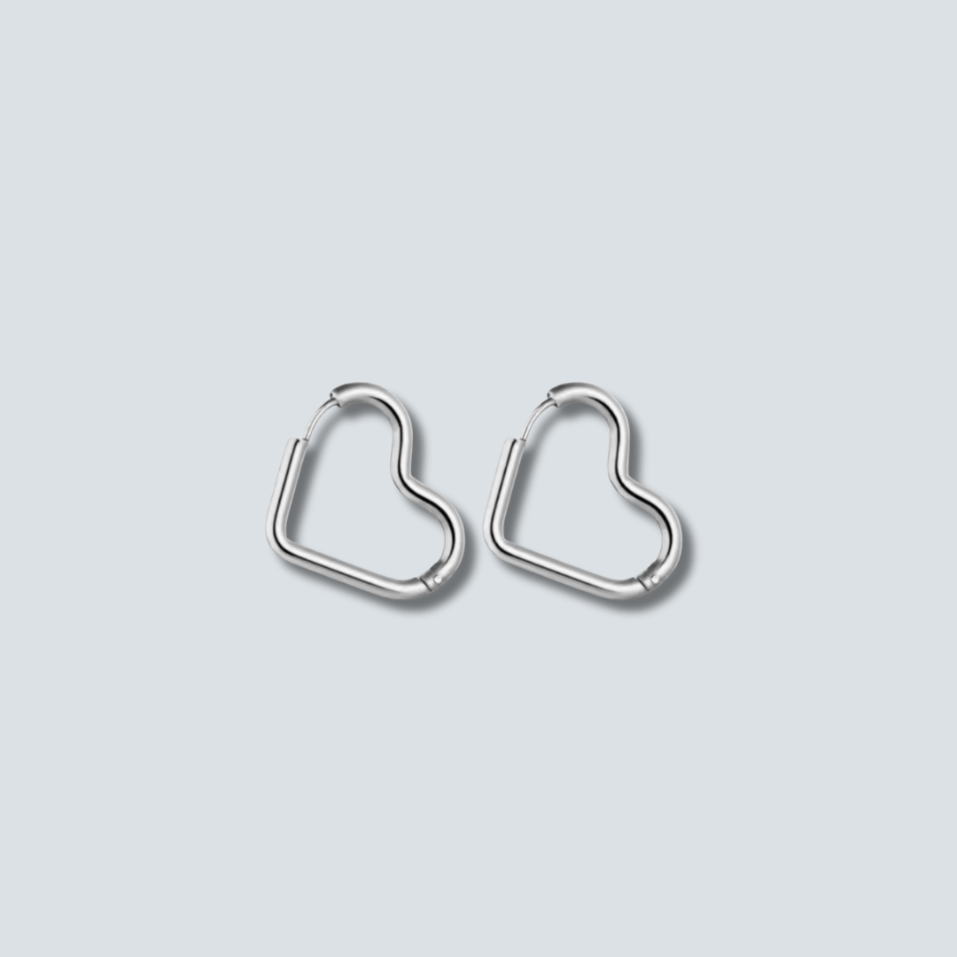 Heart-shaped silver hoop earrings on a light gray background