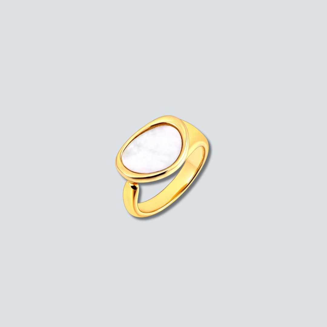Gold ring with a white stone on a light gray background