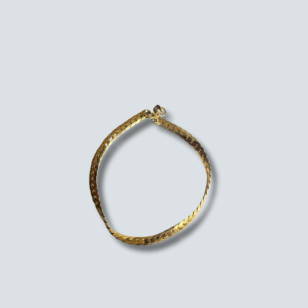 Gold bracelet on a light gray background