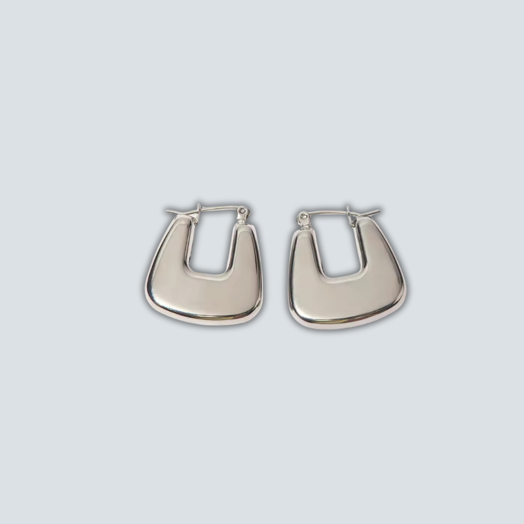 Pair of silver hoop earrings on a light gray background