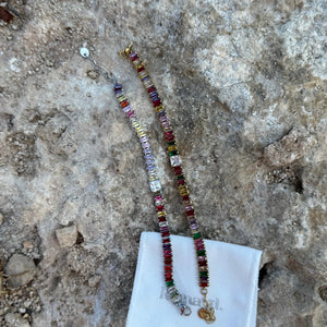 Colorful beaded BRACELET on a white cloth with a textured stone background