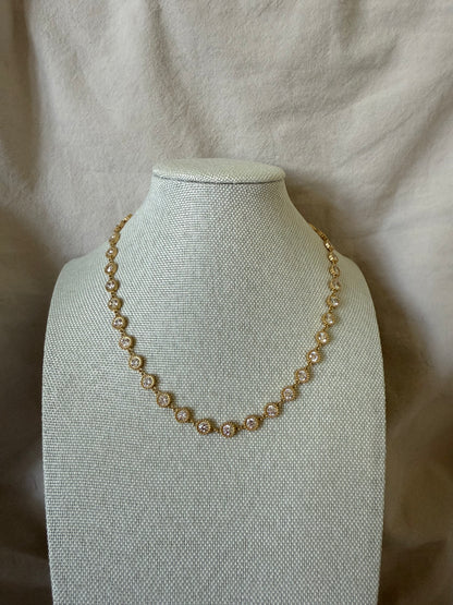 Pearl necklace on a mannequin bust against a beige fabric background