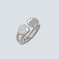 Silver ring with two rounded stones on a light gray background