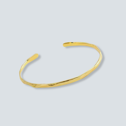 Gold ADJUSTABLE bangle on a light grEy background