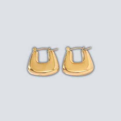 Gold hoop earrings on a light gray background