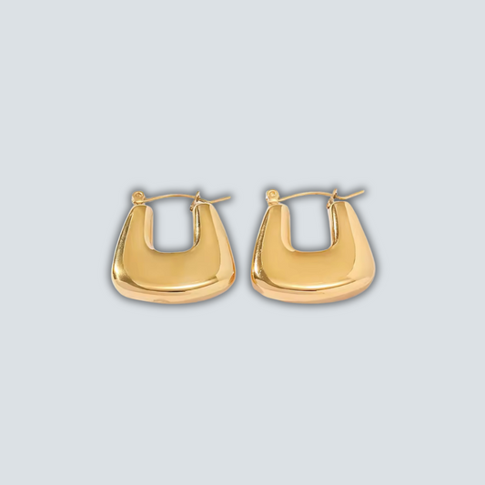 Gold hoop earrings on a light gray background