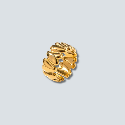 Gold earring on a light gray background