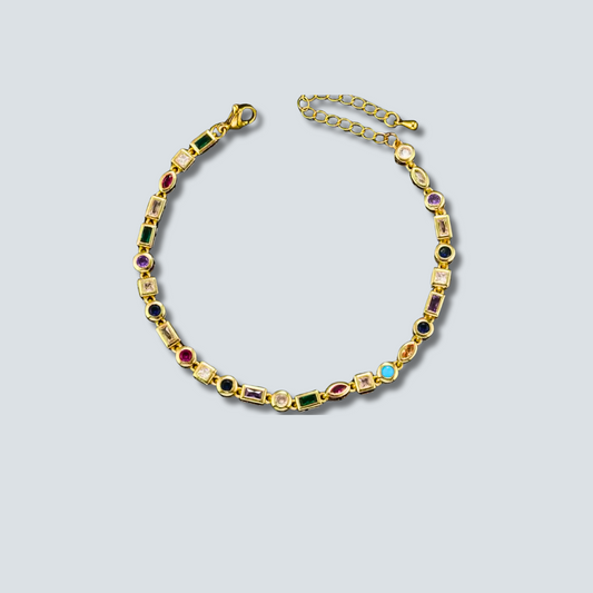 Gold bracelet with colorful gemstones on a light gray background