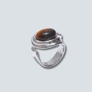 Silver ring with a brown gemstone on a light gray background