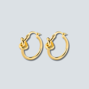Gold hoop earrings on a light gray background