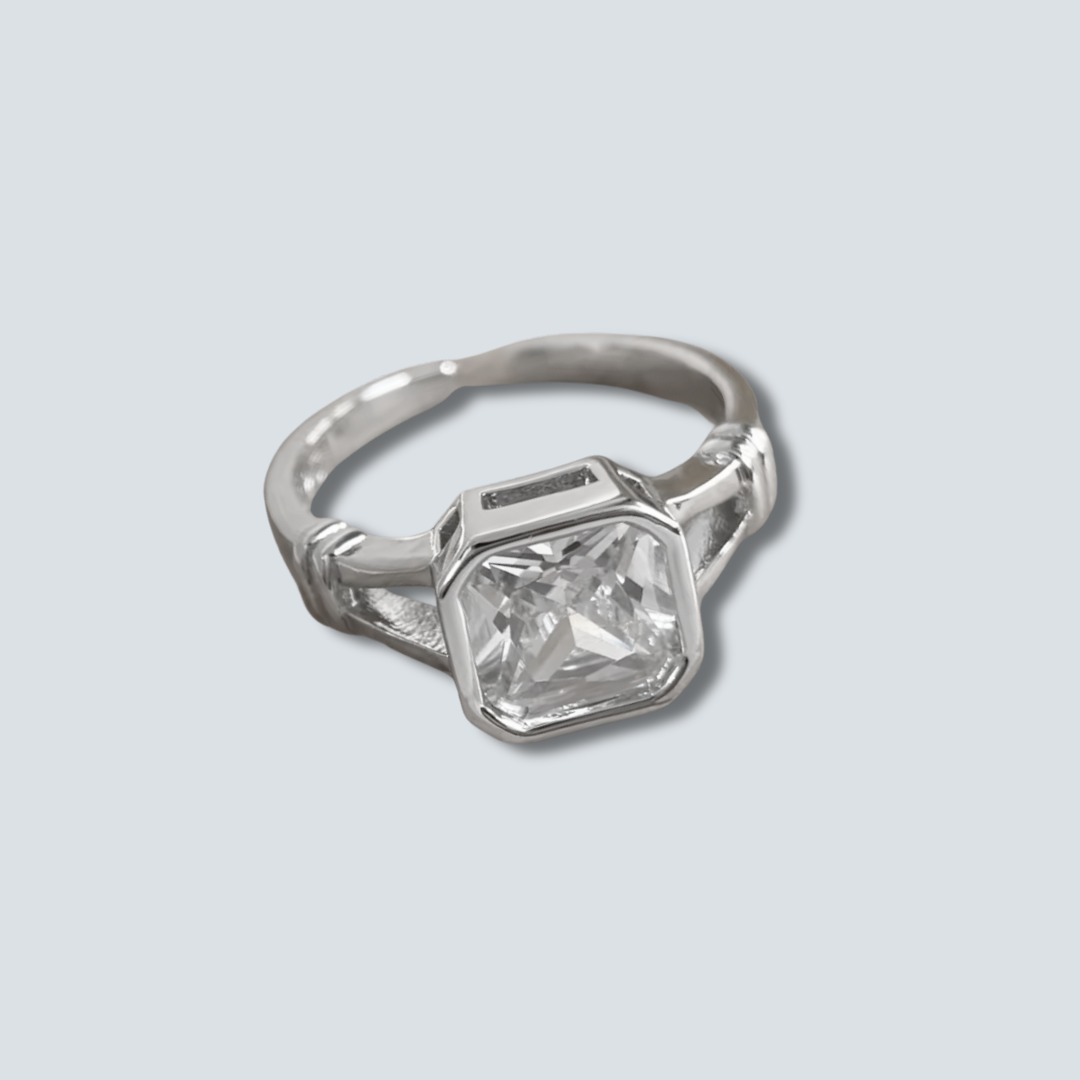 Silver ring with a large diamond on a light gray background
