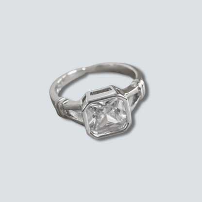 Silver ring with a large diamond on a light gray background