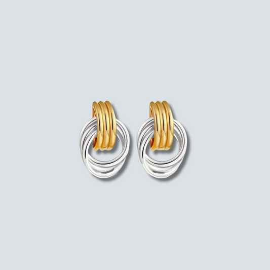 Pair of gold and silver hoop earrings on a light gray background