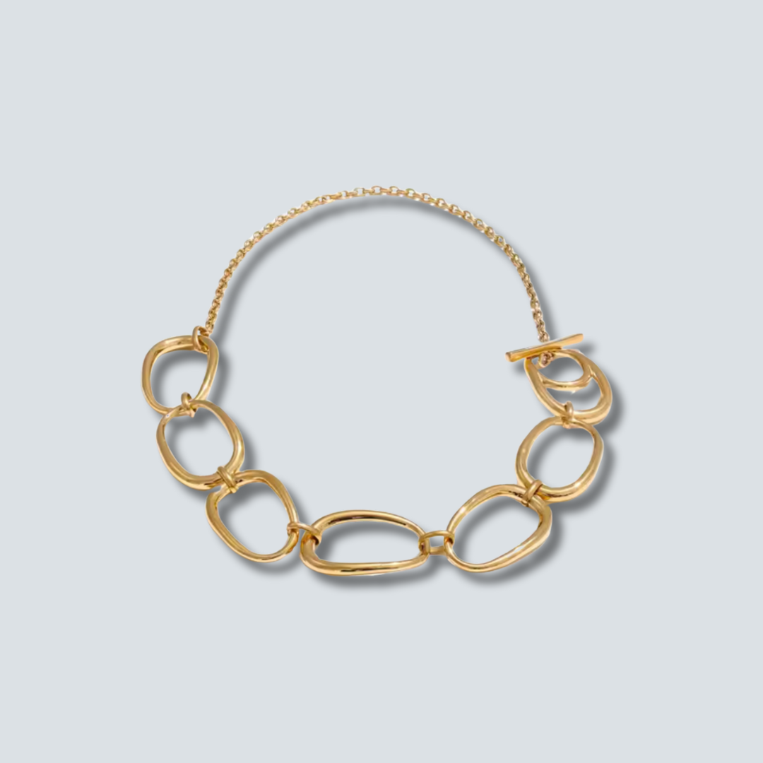 Gold chain necklace on a light gray background