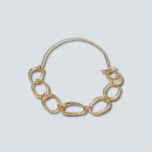 Gold chain necklace on a light gray background