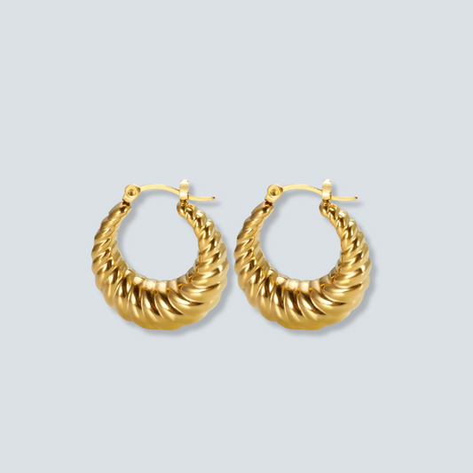 Gold hoop earrings on a light gray background