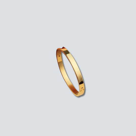 Gold bracelet on a light gray background