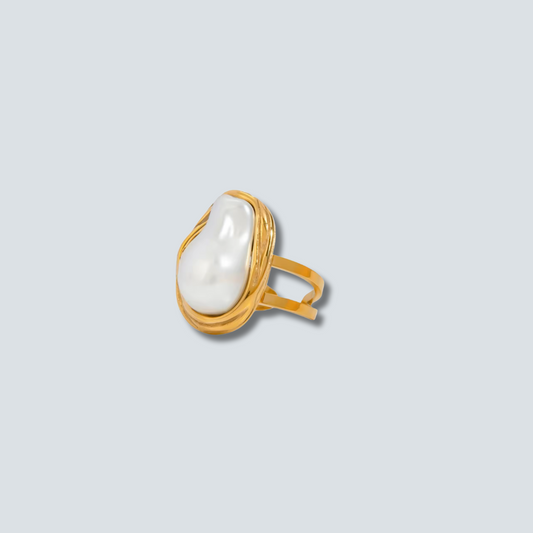 Gold ring with a large pearl on a light gray background