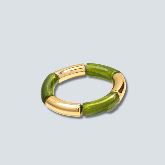 Green bracelet with gold accents on a light gray background