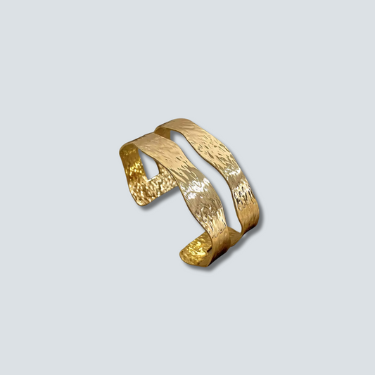 Gold bracelet on a light gray background