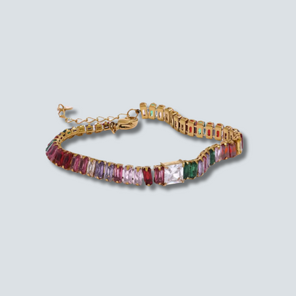Gold bracelet with colorful gemstones on a light gray background
