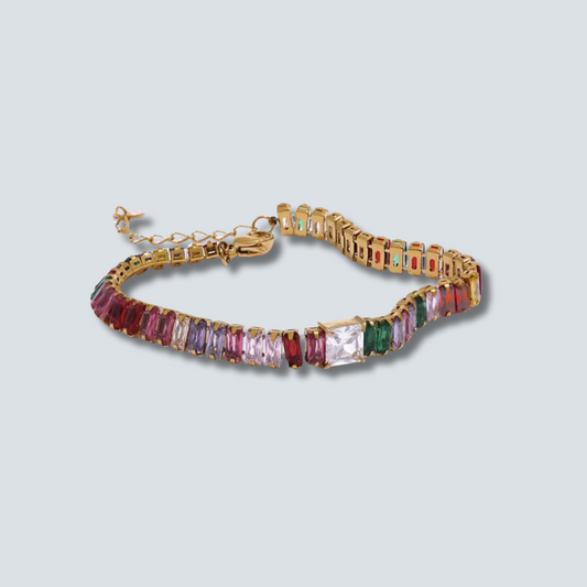 Gold bracelet with colorful gemstones on a light gray background
