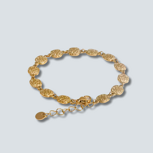 Gold bracelet on a light gray background