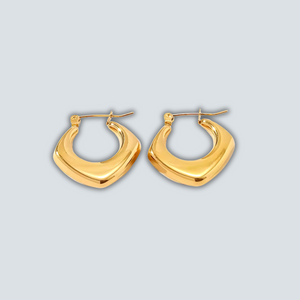 Gold hoop earrings on a light gray background