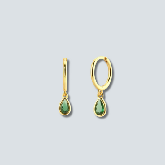 Gold earrings with green teardrop stones on a light gray background